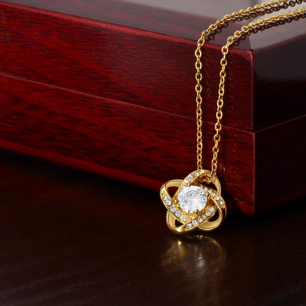18K yellow gold Eternal Hope Necklace close-up beside a luxury wood gift box